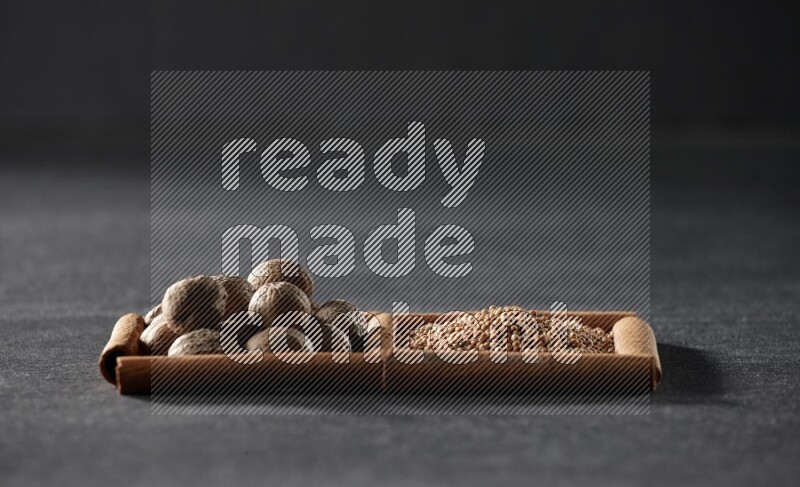 2 squares of cinnamon sticks full of mustard seeds and nutmeg on black flooring