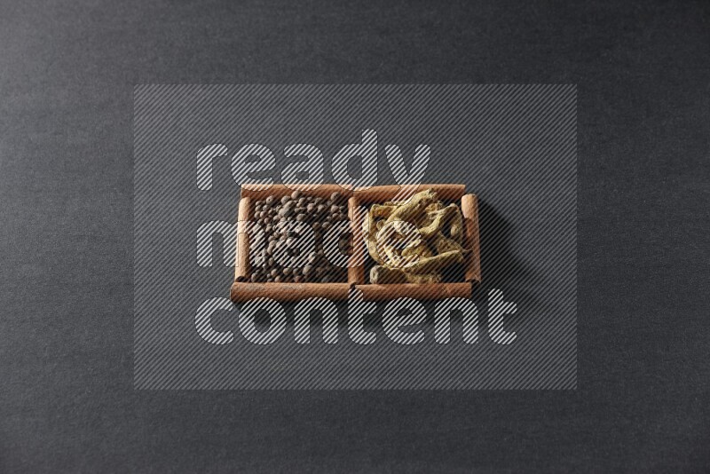 2 squares of cinnamon sticks full of allspice and turmeric fingers on black flooring