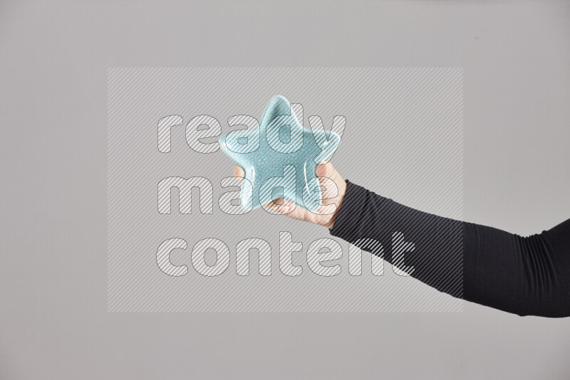 A woman in black abaya holding different pottery essentials in different positions