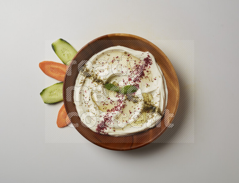 Lebnah garnished with  zattar , sumak & mint in a wooden plate on a white background