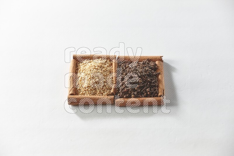 2 squares of cinnamon sticks full of cloves and sesame on white flooring