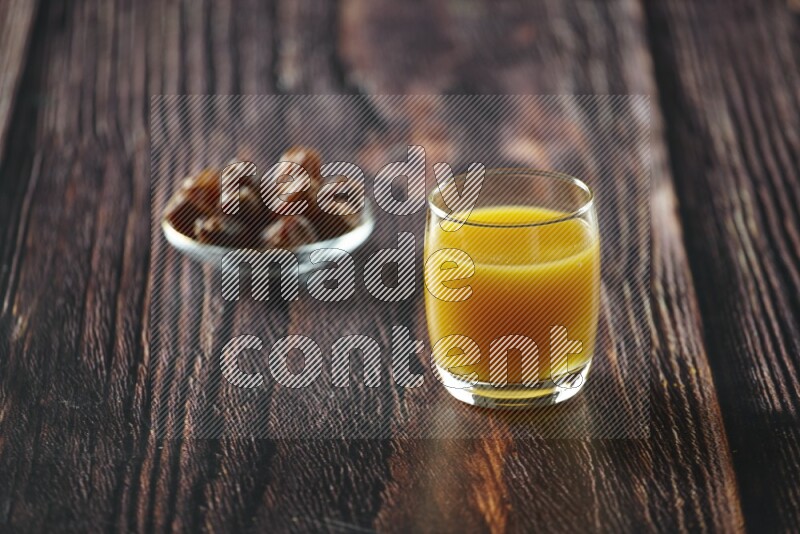 Cold drinks in a glass cup with dates such as water, tamarind, qamar eldin, sobia, milk and hibiscus on wooden background