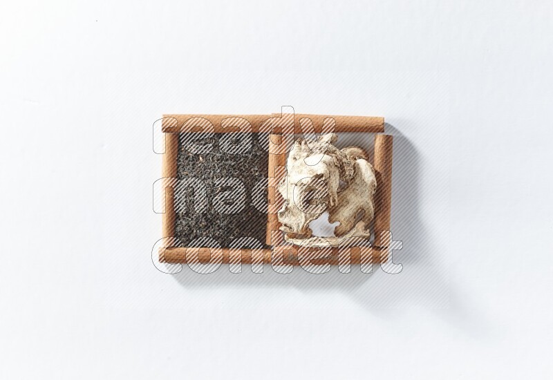 2 squares of cinnamon sticks full of black tea and dried ginger on white flooring