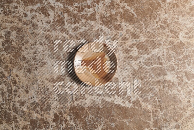 A multicolored pottery plate on beige marble background