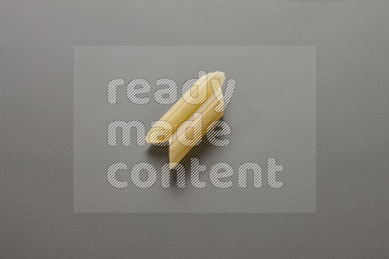 Mini penne pasta on grey background