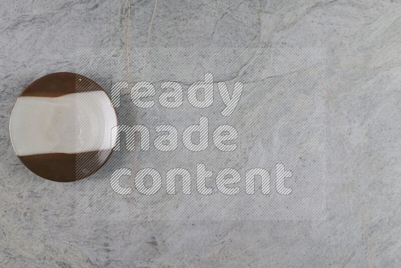 A multicolored pottery plate on grey marble background