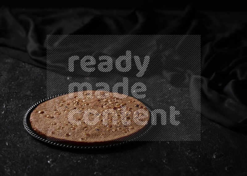 Basbousa in different plates in a dark setup