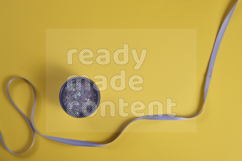 A purple collection of sewing and tailoring tools arranged on a yellow background