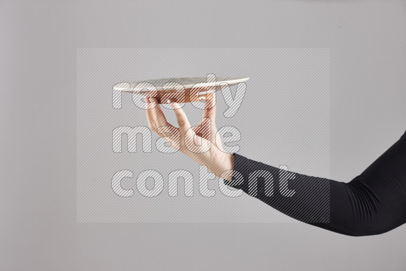 A woman in black abaya holding different pottery essentials in different positions