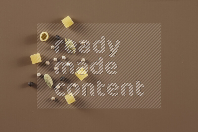 معكرونة مع مكونات متنوعة من الطماطم والثوم والبصل والفلفل الأحمر والفلفل الأسود والفلفل الأبيض وأوراق الغار وإكليل الجبل والهيل على خلفية بيج