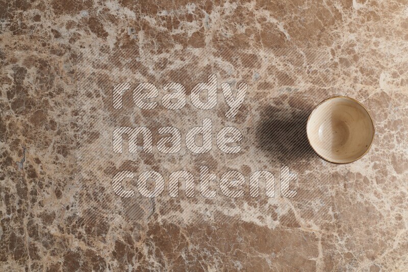 A white pottery bowl on beige marble background