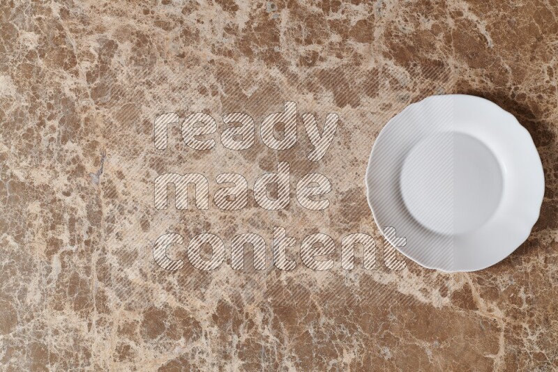 Top View Shot Of A White Ceramic Circular Plate On beige Marble Flooring