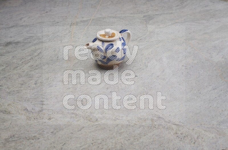 A pottery teapot on grey marble background