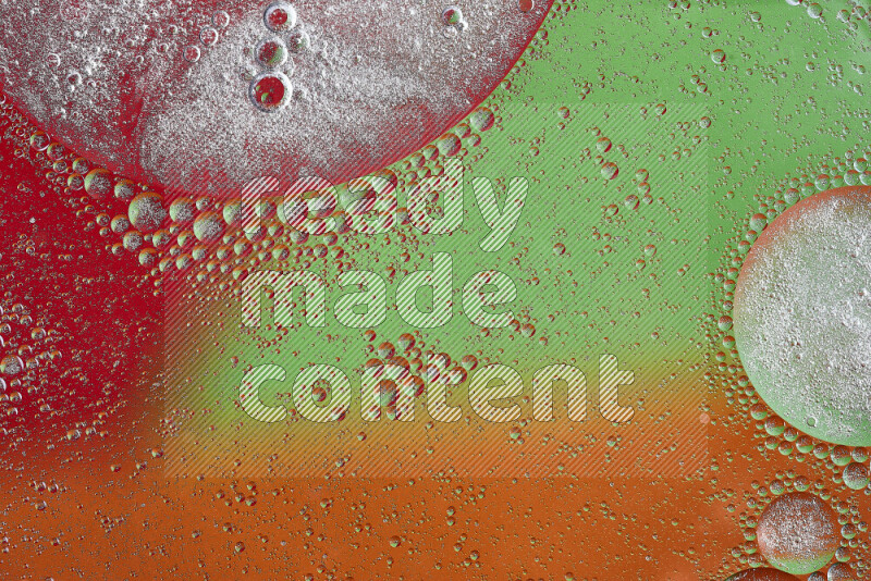 Close-ups of abstract oil bubbles on water surface in shades of orange, green and red