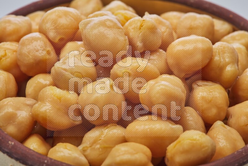 Close up of a boiled chickpeas in a container on white background