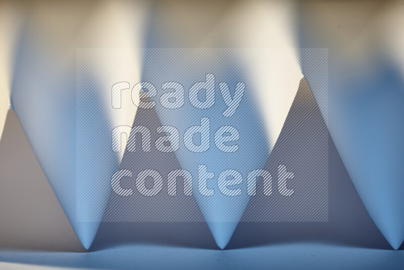 صورة مجردة مقربة تظهر طيات ورقية هندسية حادة بتدرجات اللون الأبيض و الأزرق