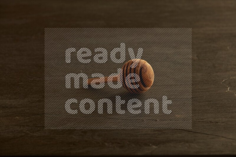 Wooden honey dipper on black slate background