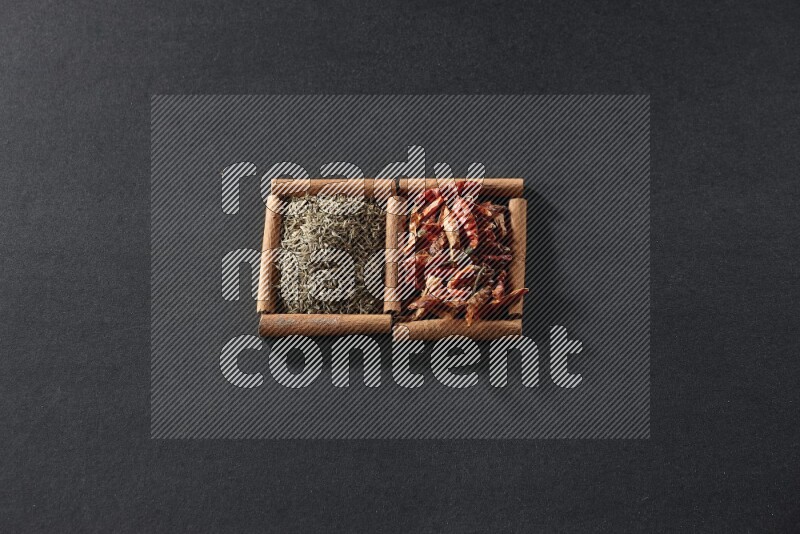 2 squares of cinnamon sticks full of chilis and cumin on black flooring