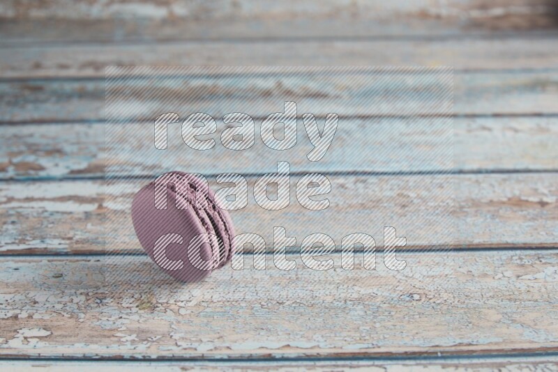 45º Shot of Purple Blueberry macaron on light blue wooden background