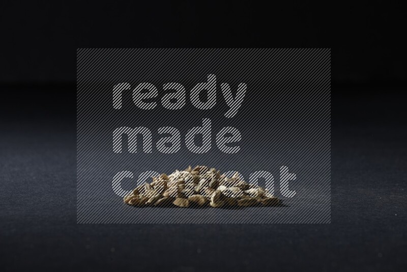 Cardamom in a triangle shape on black flooring