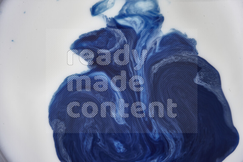 A close-up of sparkling gold glitter scattered on swirling blue background