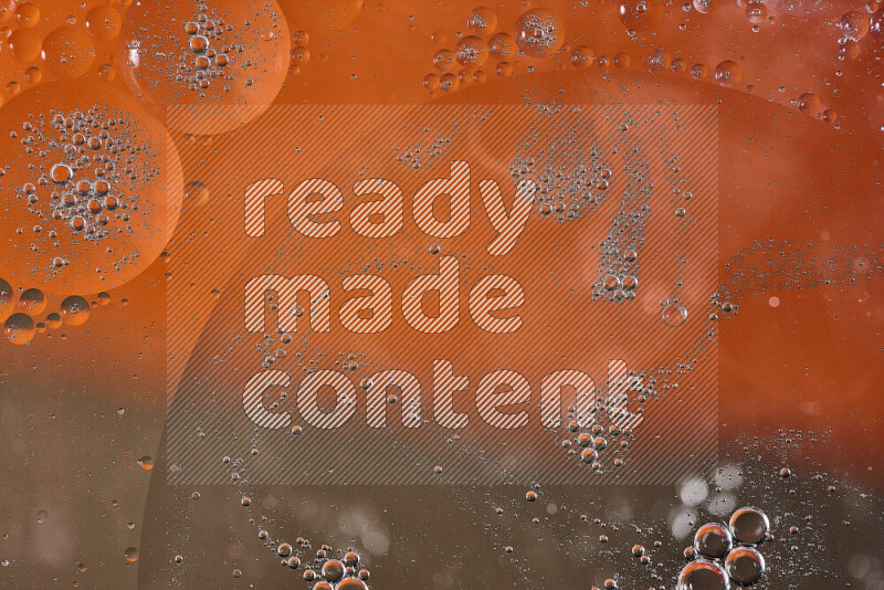 Close-ups of abstract oil bubbles on water surface in shades of orange and brown