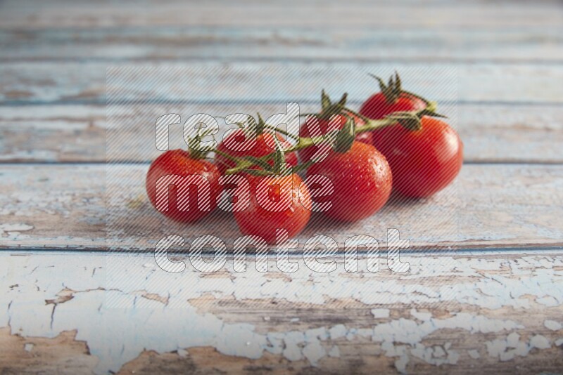 Red cherry tomato vein on a textured blue wooden background 45 degree