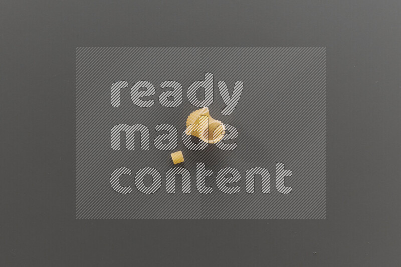 Small rings pasta with other types of pasta on grey background