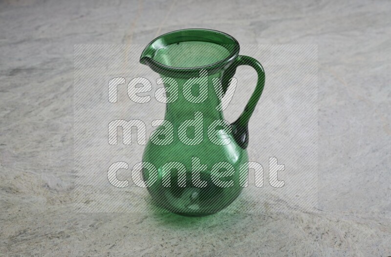 A colored glass jug on grey marble background