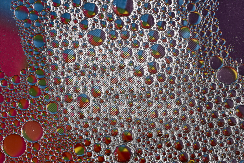 Close-ups of abstract soap bubbles and water droplets on multicolored background