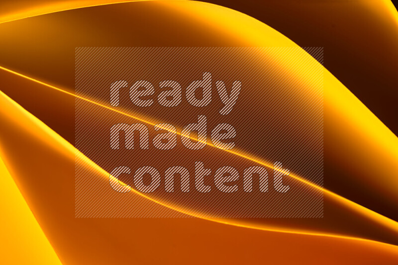 هذه الصورة تعرض تكوين فن الورق التجريدي مع منحنيات ورقية بتدرجات اللون الأصفر والأحمر والبني المكونه بواسطة الضوء الملون