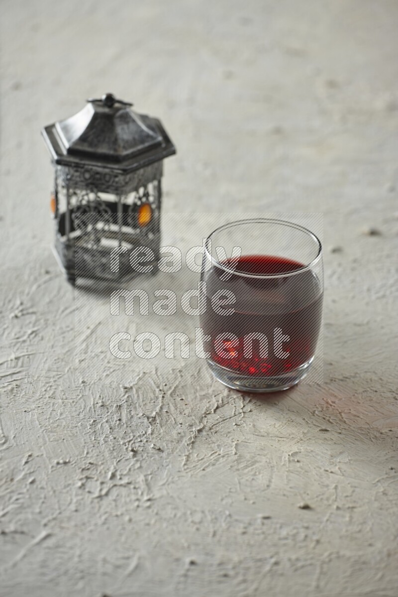 فانوس فضي مع مشروبات مختلفة وتمر ومكسرات وسبحة صلاة وقرآن على خلفية بيضاء