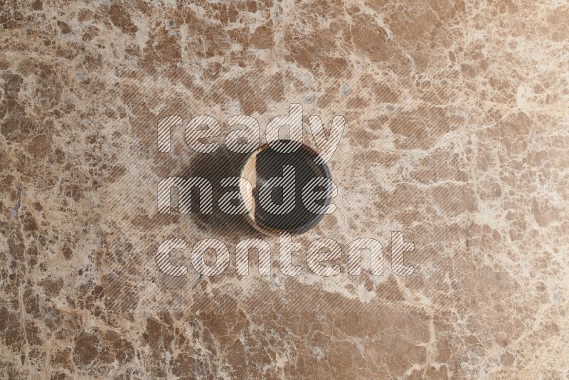 A multicolored pottery bowl on beige marble background