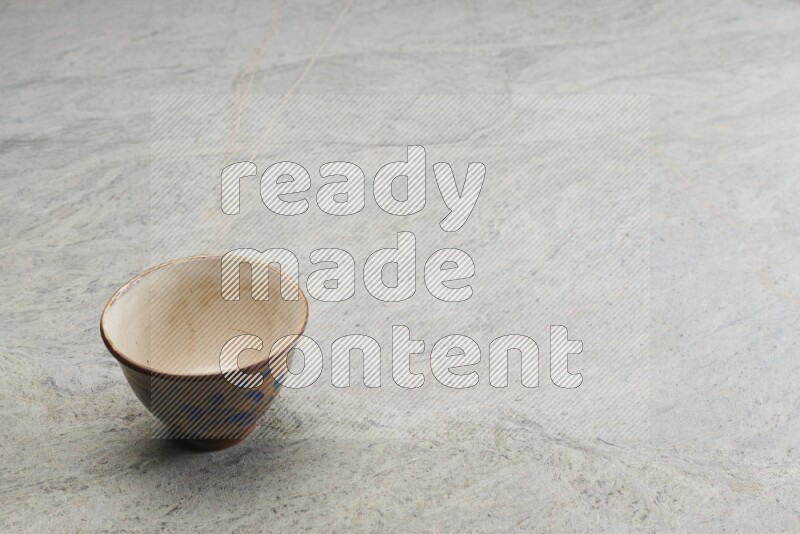 A multicolored pottery bowl on grey marble background