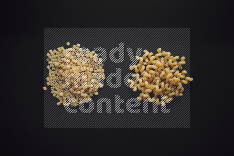 Different pasta types in bunches on black background