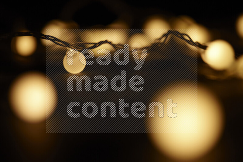 Light bulbs glowing against backdrop of golden bokeh