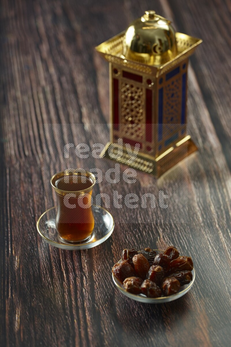 A golden lantern with different drinks, dates, nuts, prayer beads and quran on brown wooden background
