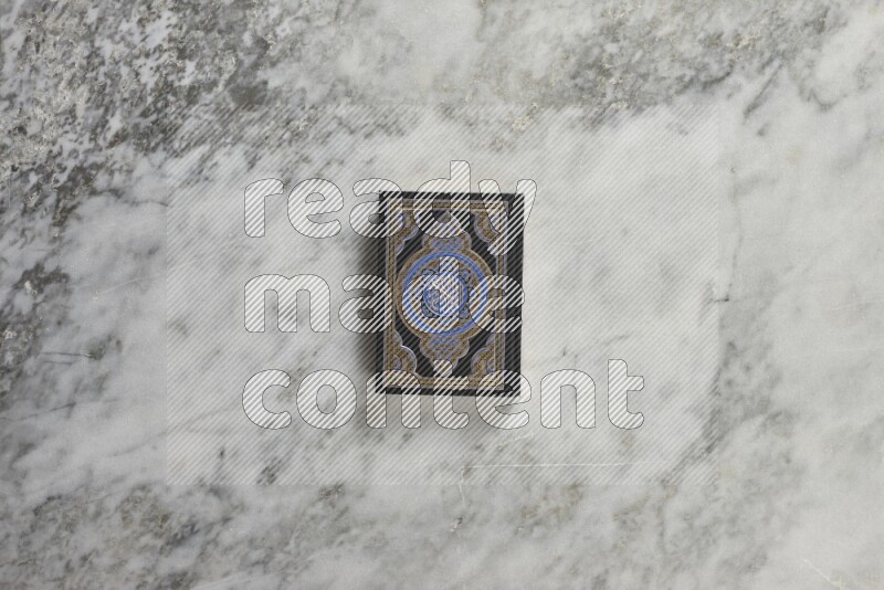 Quran with a prayer beads on grey marble background