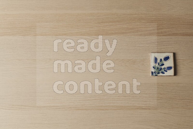 A decorative pottery coaster on light wooden background