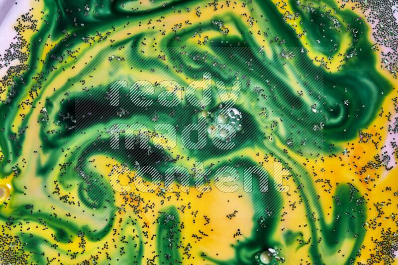 A close-up of sparkling green glitter scattered on swirling yellow and green background