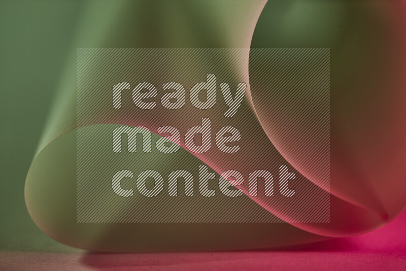 An abstract art piece displaying smooth curves in green and red gradients created by colored light