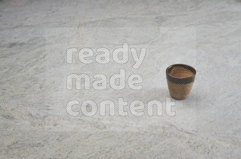 A multicolored pottery Cup on grey marble background