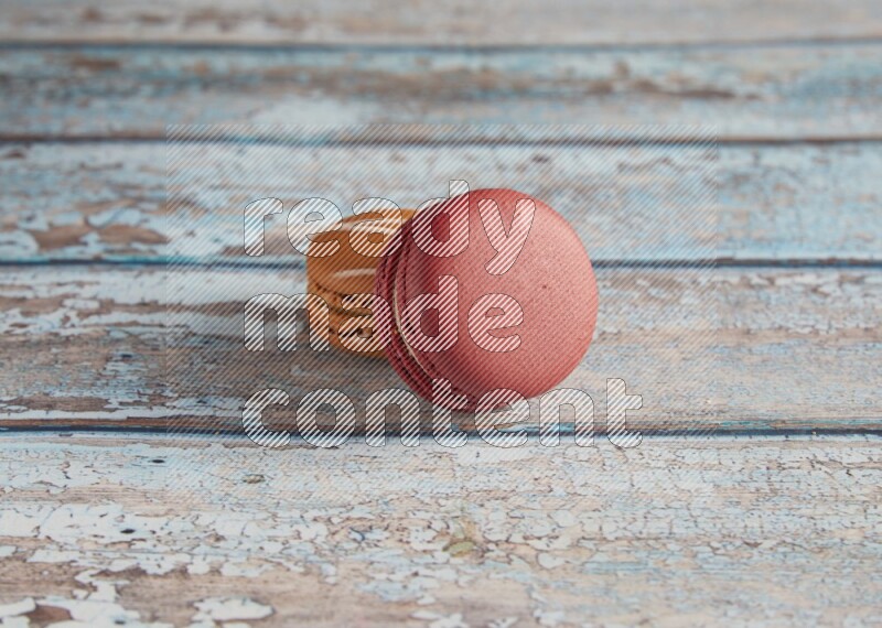 45º Shot of of two assorted Brown Irish Cream, and Red Velvet macarons on light blue background