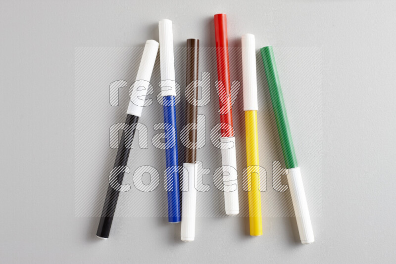 An arrangement of coloring pens in different colors on grey background