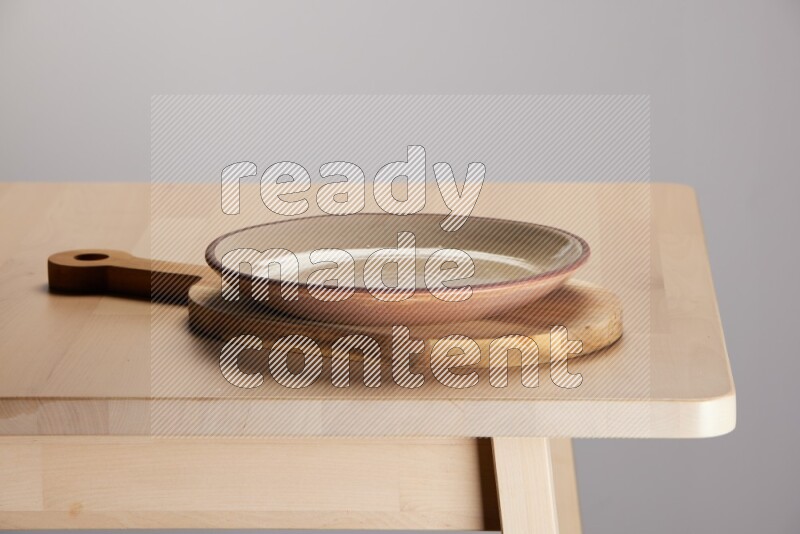 multi colored plate placed on a  wooden oval cutting board on the edge of wooden table