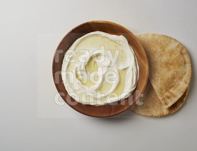 Lebnah garnished with olive oil in a wooden plate on a white background