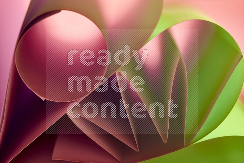An artistic display of paper folds creating a harmonious blend of geometric shapes, highlighted by soft lighting in green and red tones