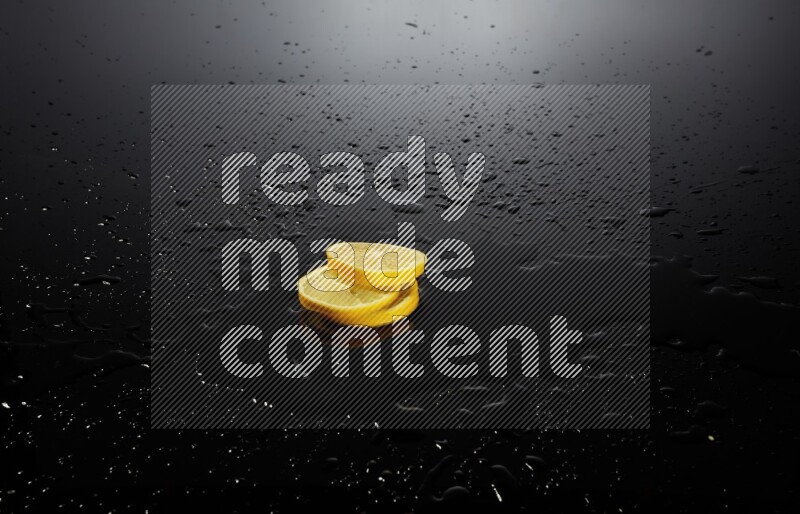Lemon slices with water drops, and droplets on black background