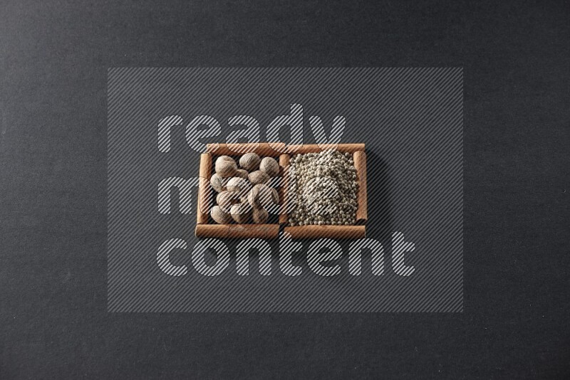 2 squares of cinnamon sticks full of nutmeg and white peppers on black flooring