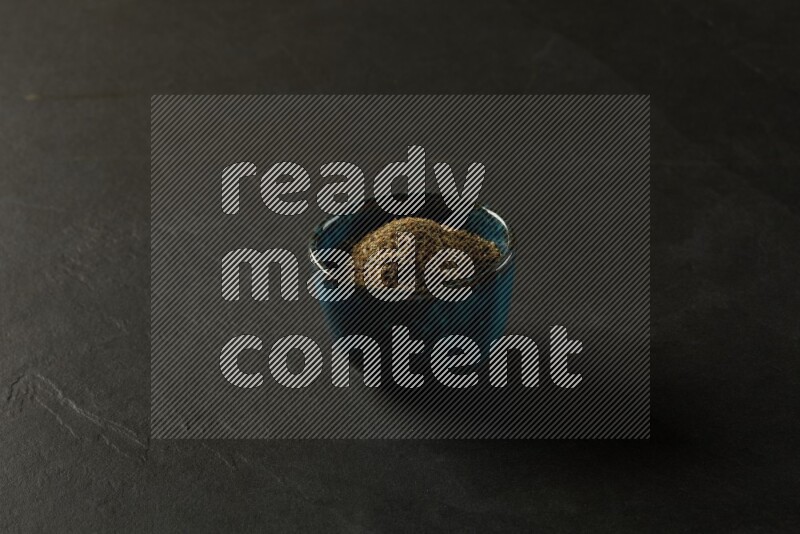 multi color round sauce bowl filled with herbs on grey textured countertop